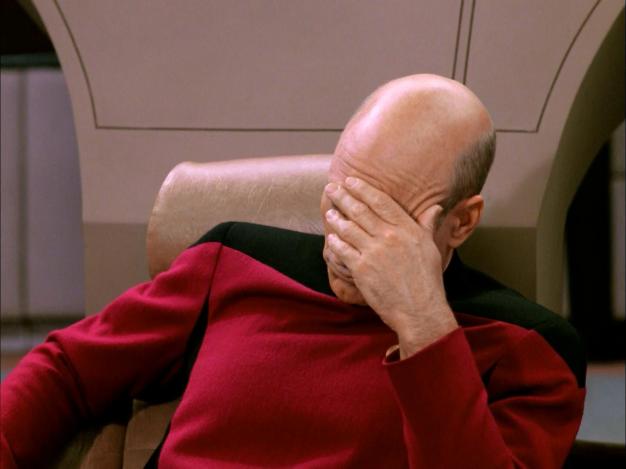 Captain Picard, slumped and holding his hand to his face.