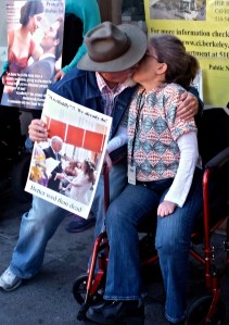Ken Stein and Ingrid Tischer, organizers of the protest, kiss, holding a poster with a photograph of their wedding.